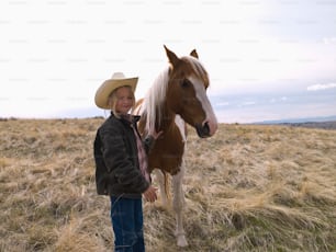 Authentic young cowgirl on range with horse in Big Timber, Montana