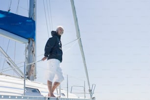 a man standing on a sailboat on a sunny day