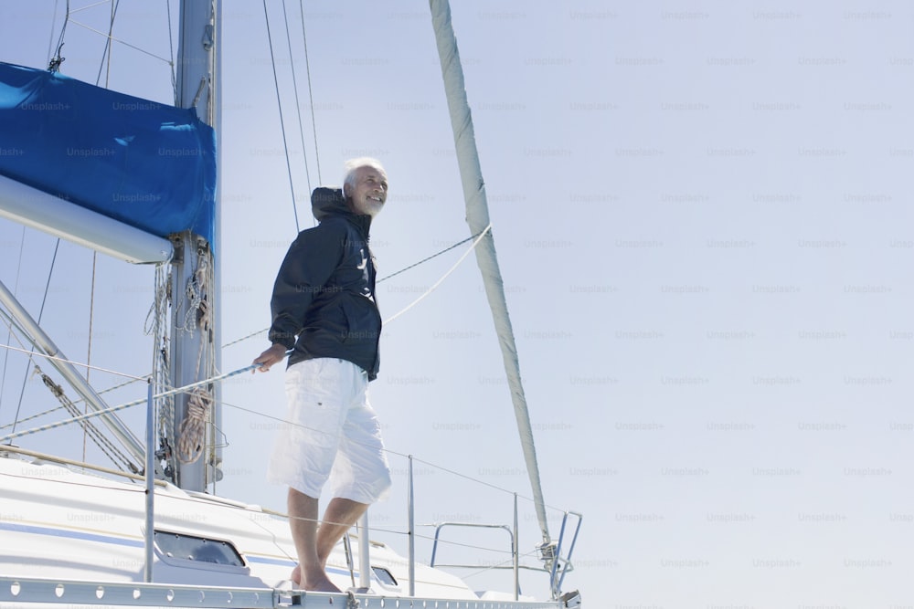 Ein Mann, der an einem sonnigen Tag auf einem Segelboot steht