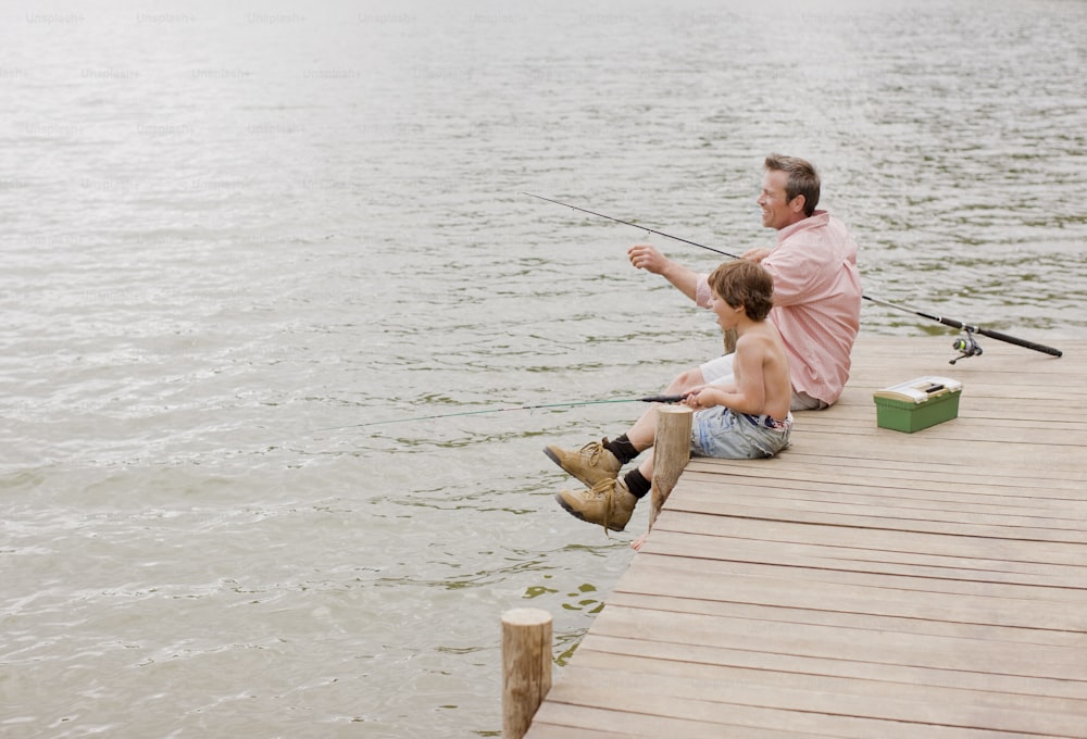 a man and a boy fishing on a dock