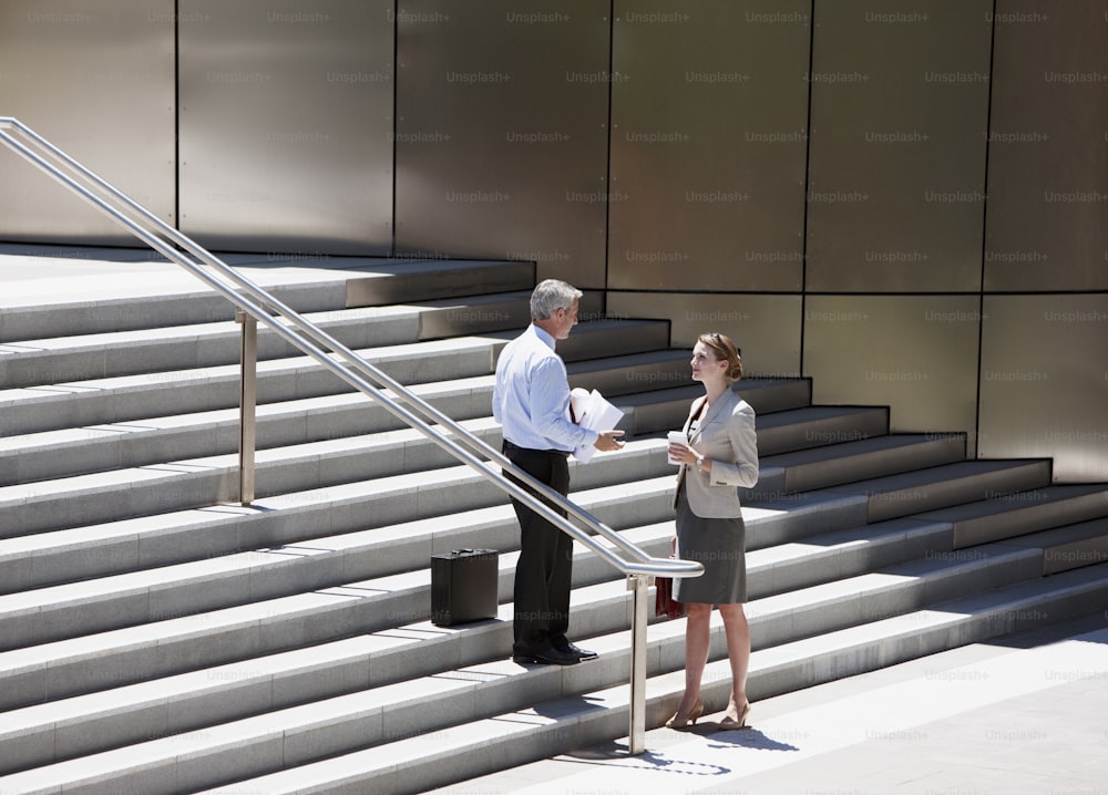 Un hombre y una mujer parados en la parte inferior de un conjunto de escaleras