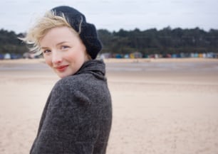 a woman standing on top of a sandy beach