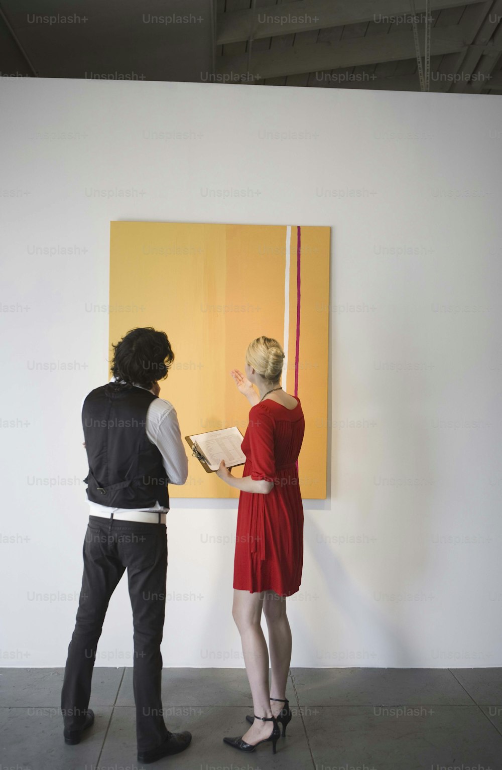 a man and a woman standing in front of a painting