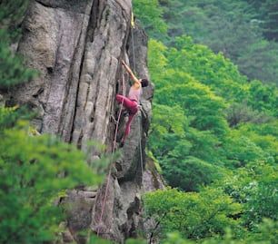 a man climbing up the side of a mountain