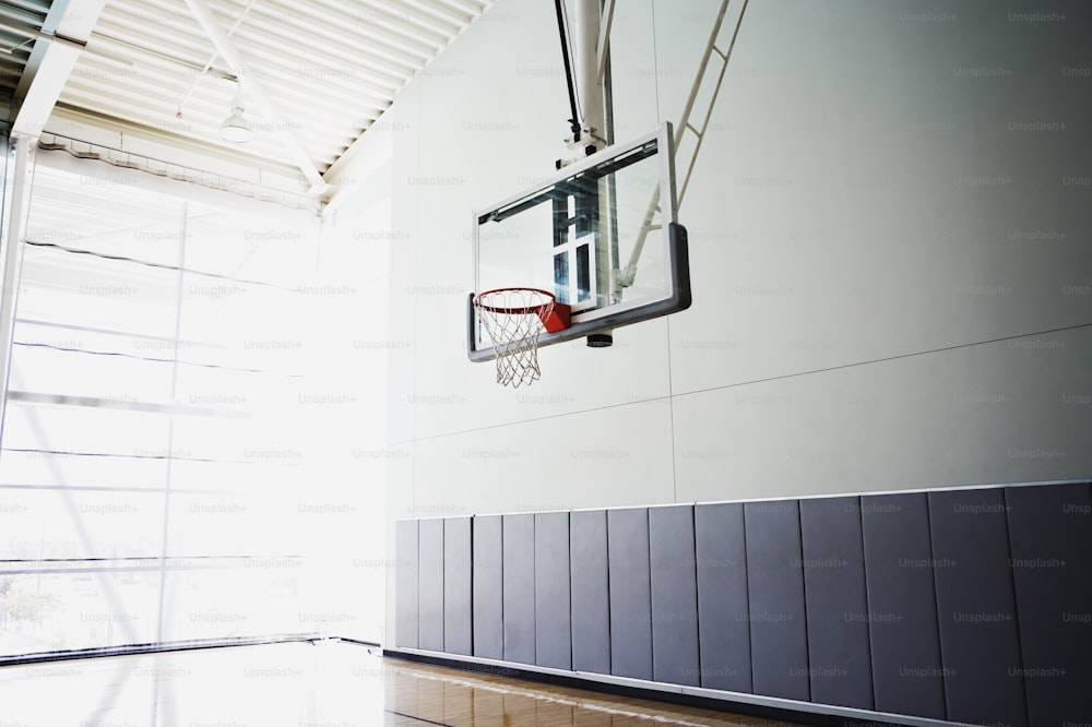 a basketball hoop hanging from the side of a basketball court