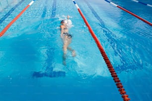 a person swimming in a pool with a red and white line