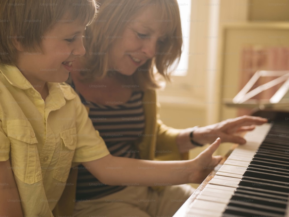 a woman and a child playing a piano