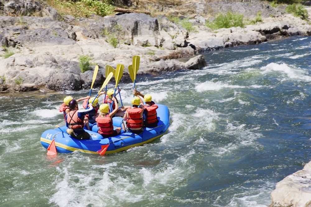 a group of people riding on top of a raft down a river