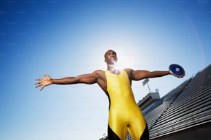 Un hombre con un traje amarillo y negro sosteniendo un frisbee