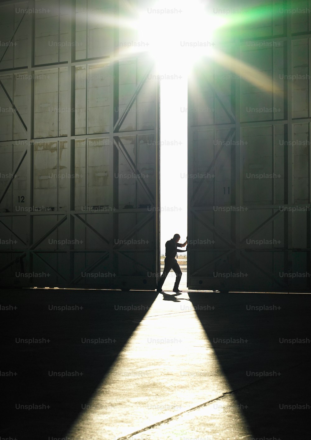 a person walking through a doorway with the sun shining on them