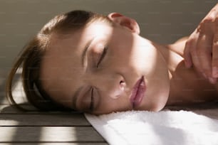 a woman laying down on a towel with her eyes closed