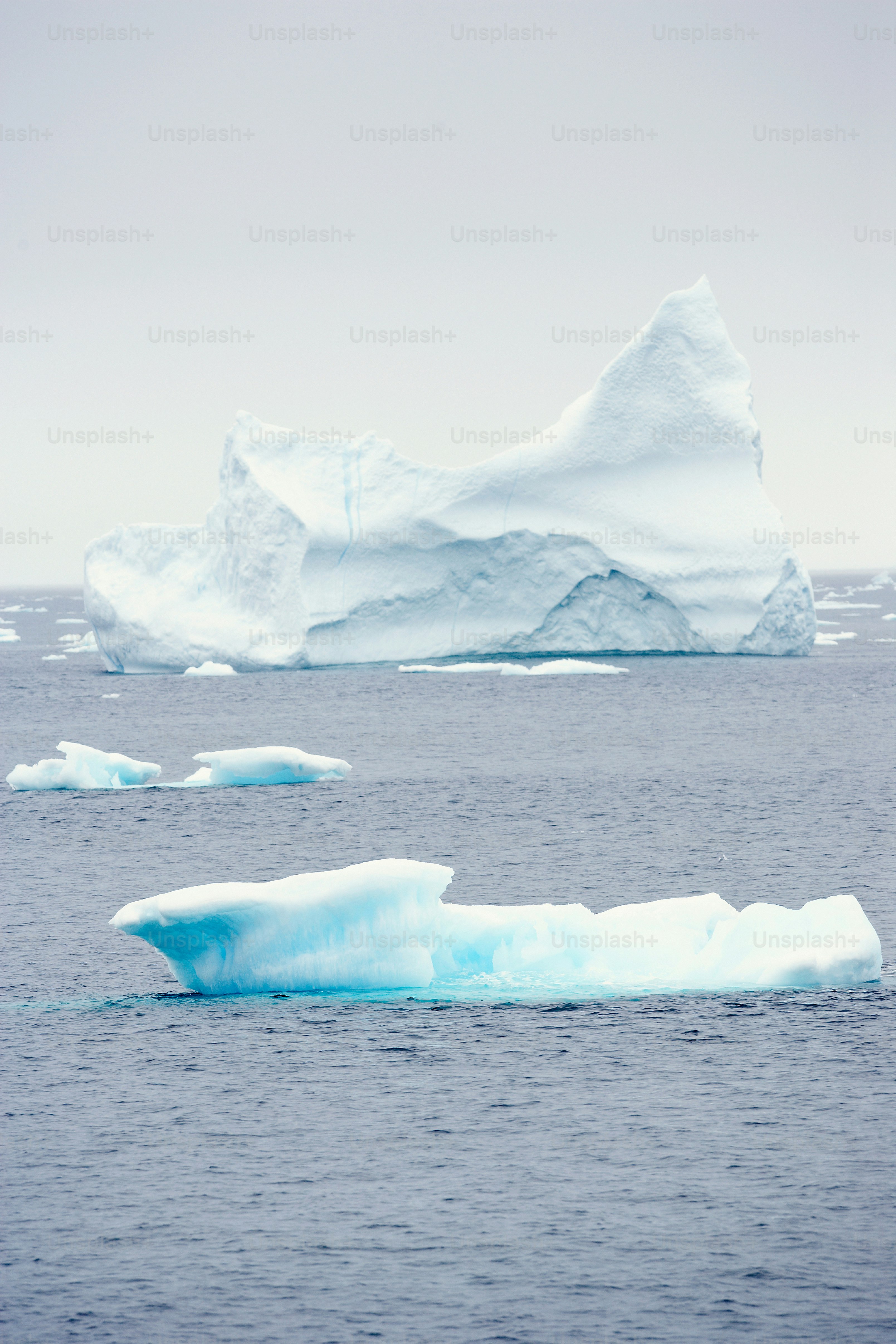 A large iceberg floating in the middle of the ocean photo – Iceberg ...