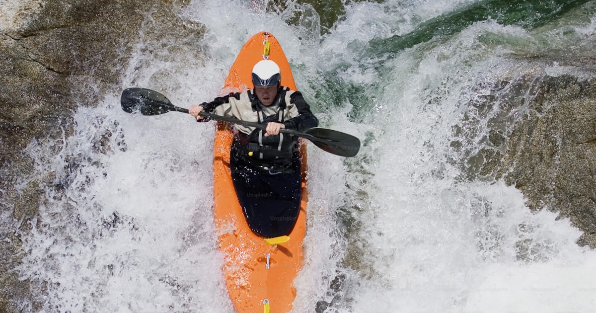 A man riding a kayak on top of a river photo – White water Image on ...