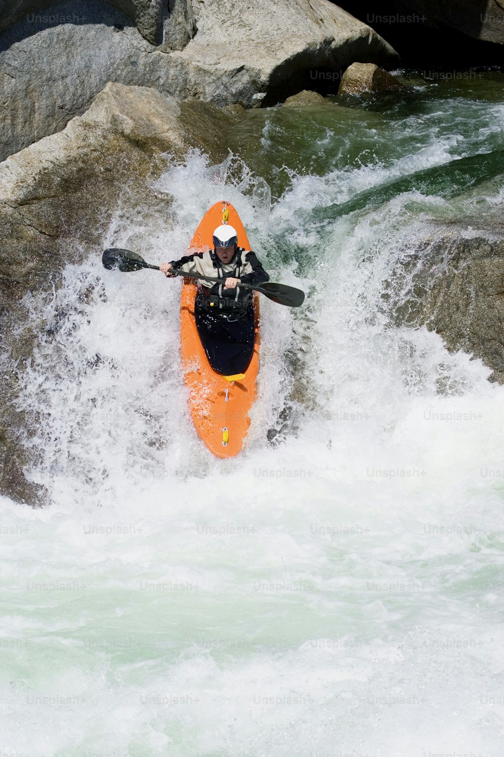 a man riding a kayak on top of a river