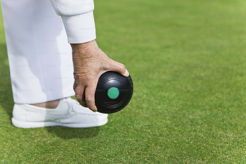 a close up of a person holding a black ball