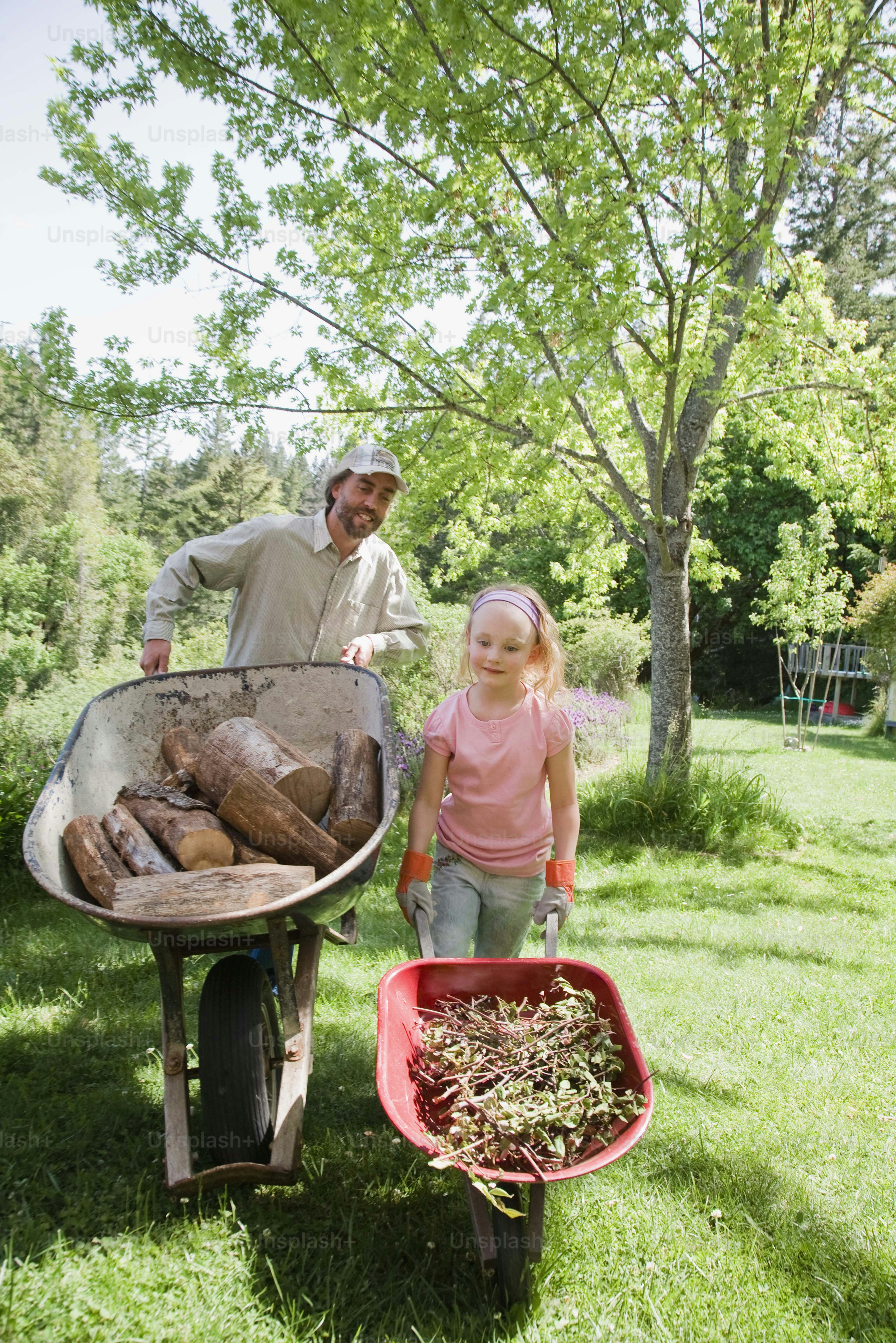 a man and a little girl standing next to a wheelbarrow