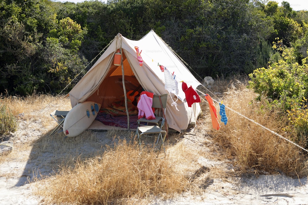 una tenda allestita in un campo con i vestiti stesi ad asciugare