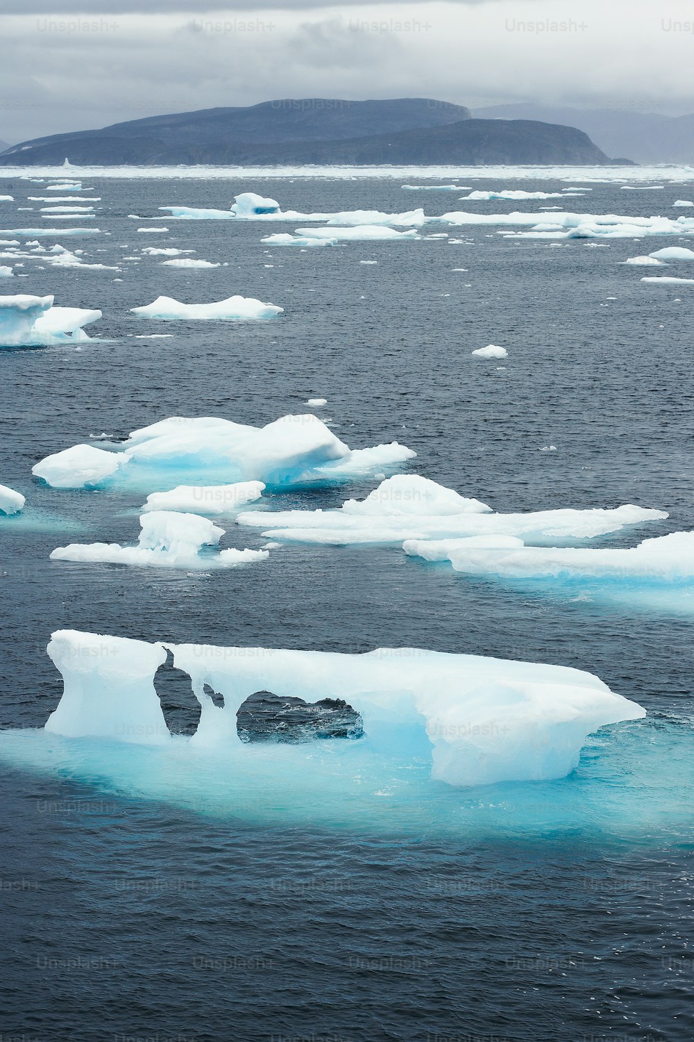 a group of icebergs floating on top of a body of water