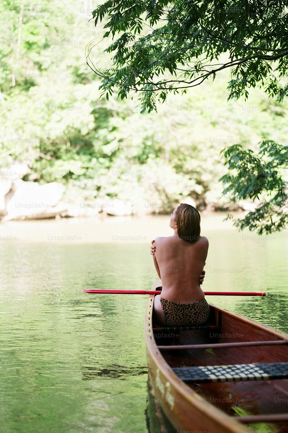 um homem sentado em uma canoa em um rio