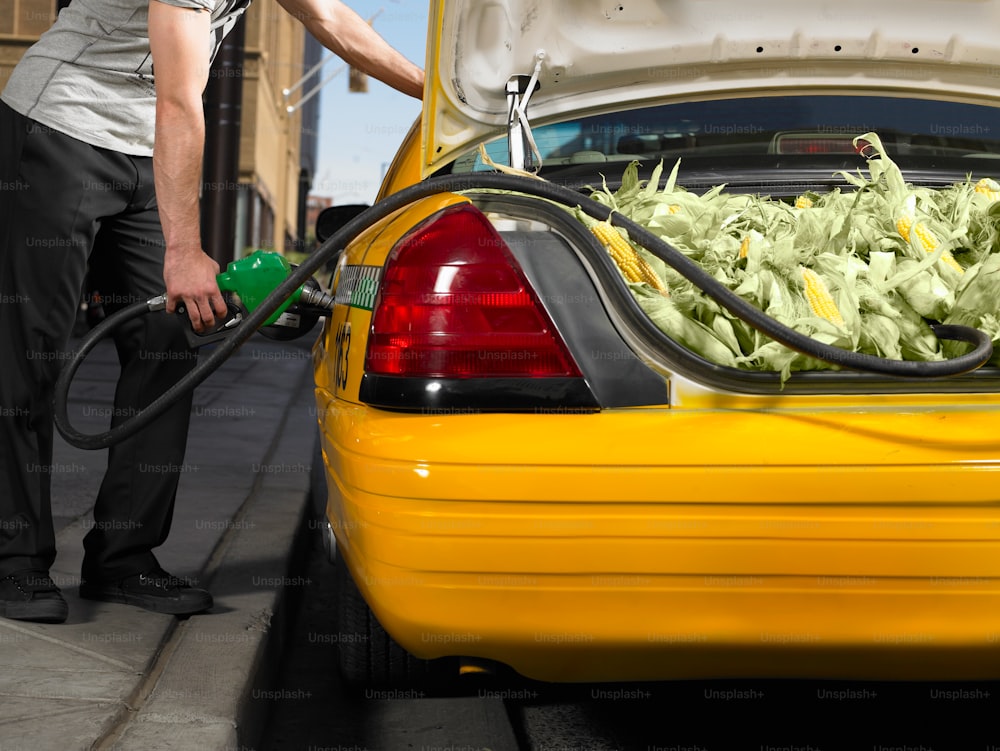 Un hombre llenando un coche amarillo con lechuga