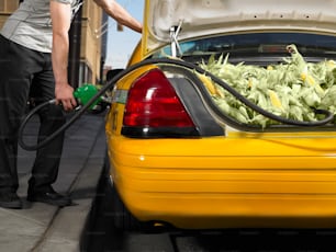 a man filling a yellow car with lettuce