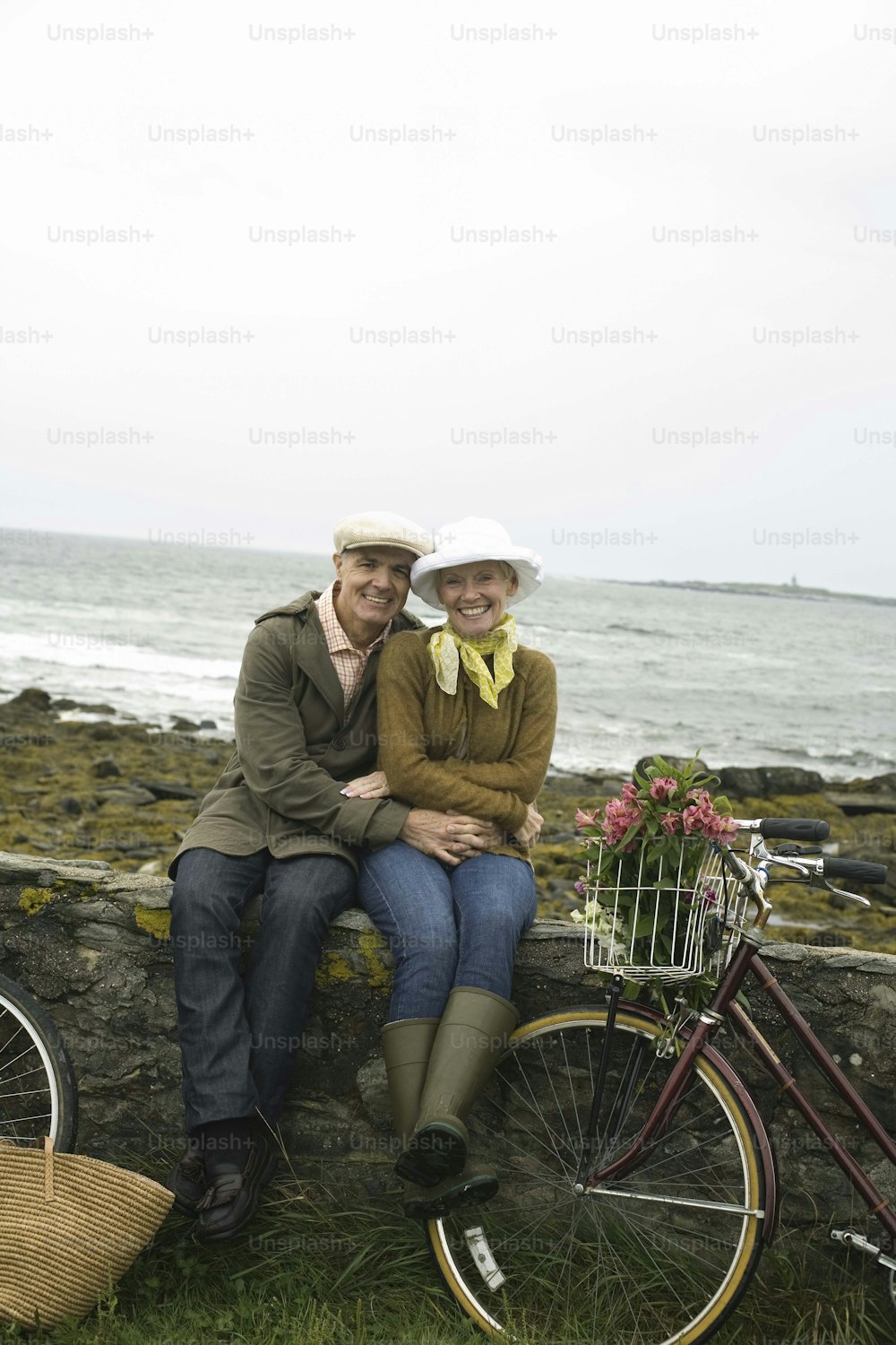 a man and woman sitting on a rock next to a bike