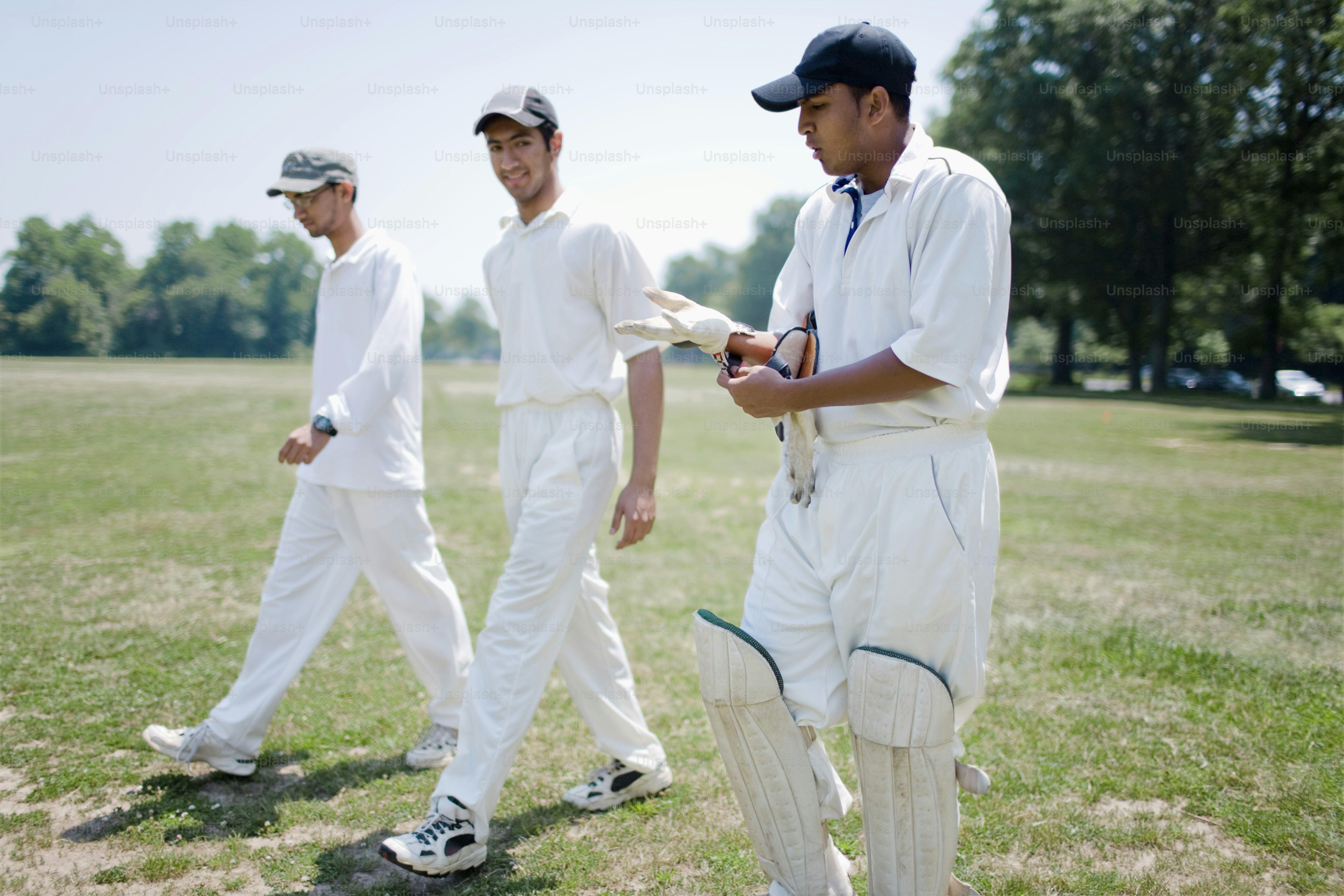 a group of men standing on top of a lush green field