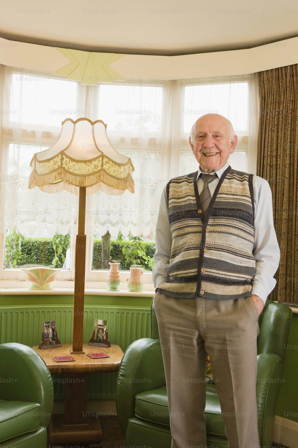 a man standing in a living room next to a lamp