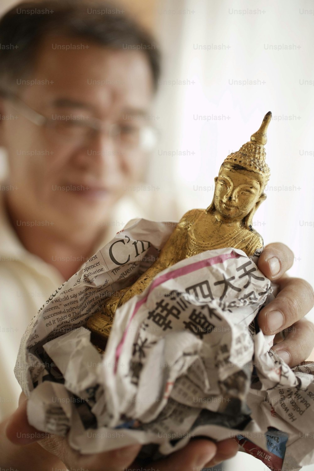 a person holding a small statue of a buddha