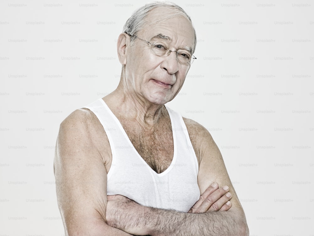 an old man with glasses and a white tank top