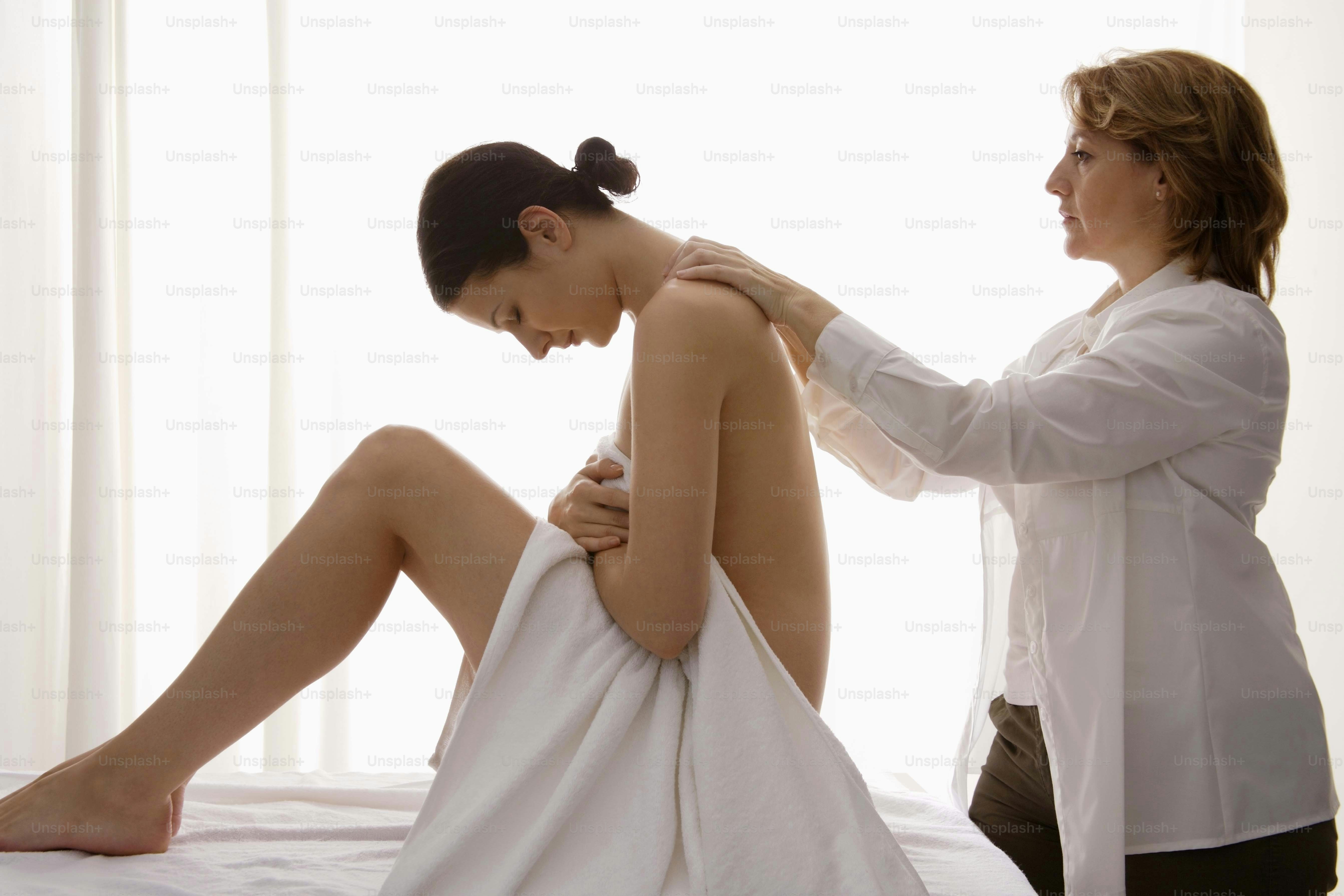 une femme qui se fait coiffer assise sur un lit