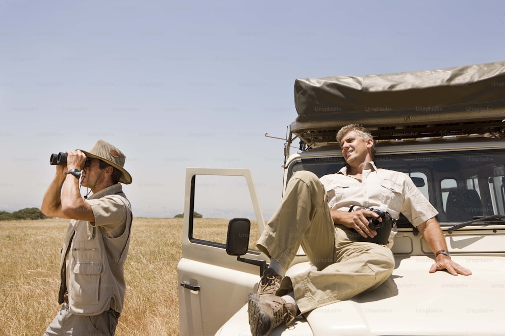 a couple of men sitting on top of a white truck