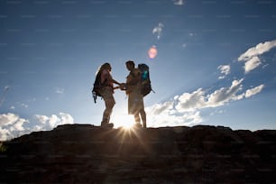 Una pareja tomada de la mano en una montaña.