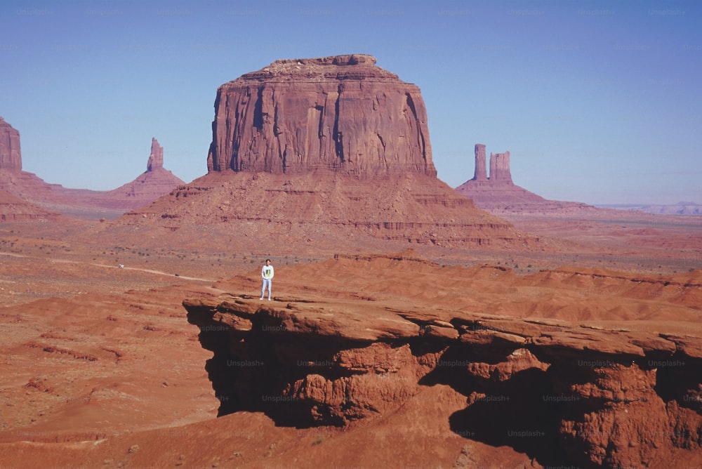 una persona in piedi sulla cima di una formazione rocciosa