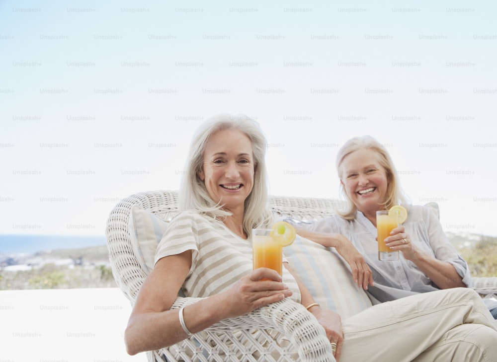 a couple of women sitting on top of a white couch