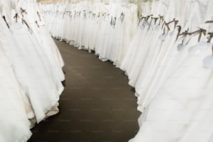 a room filled with lots of white dresses