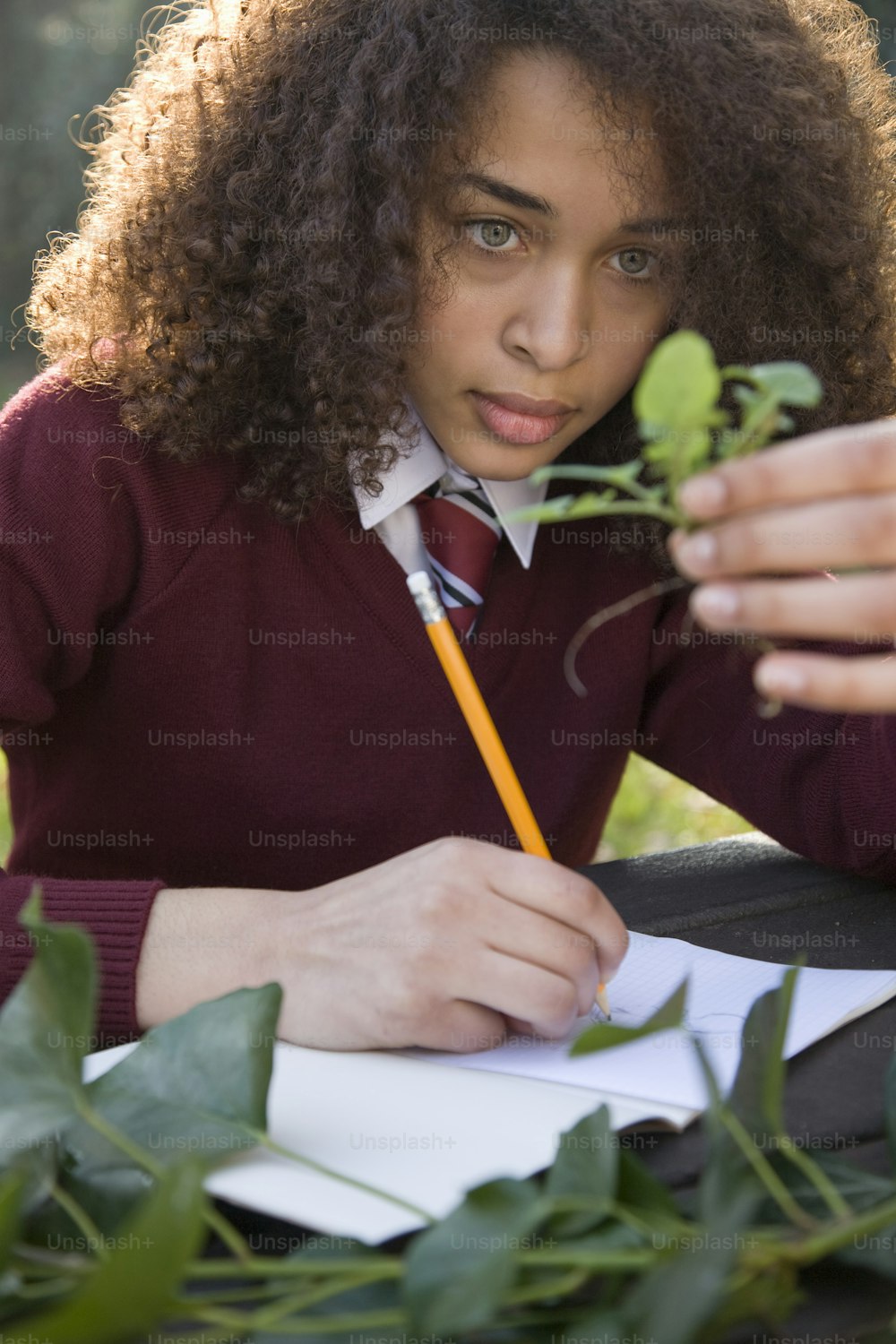 a young woman sitting at a table writing on a piece of paper