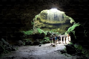 a group of people standing inside of a cave