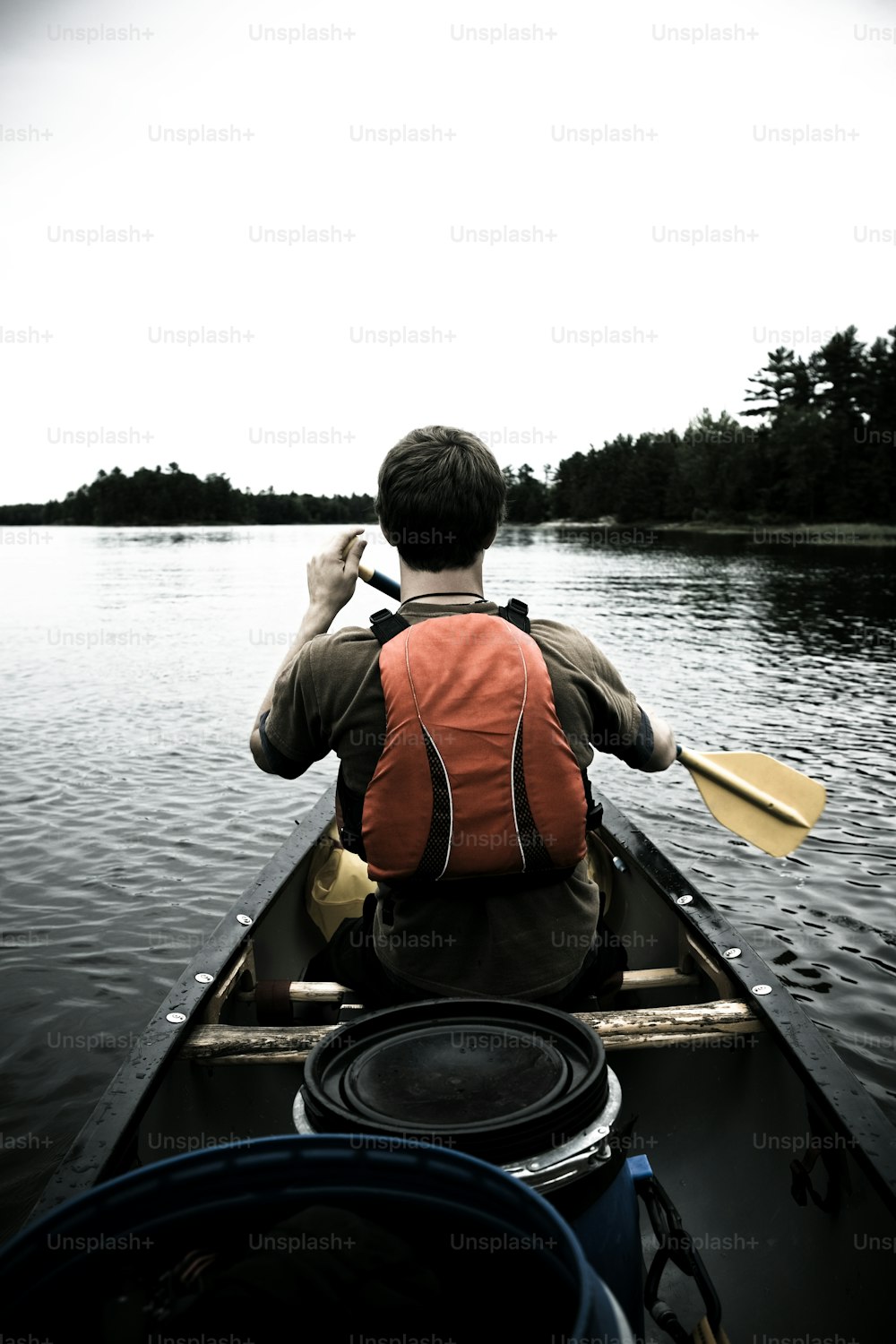 a man paddling a canoe on a lake