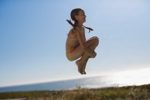 a woman in a bikini jumping into the air