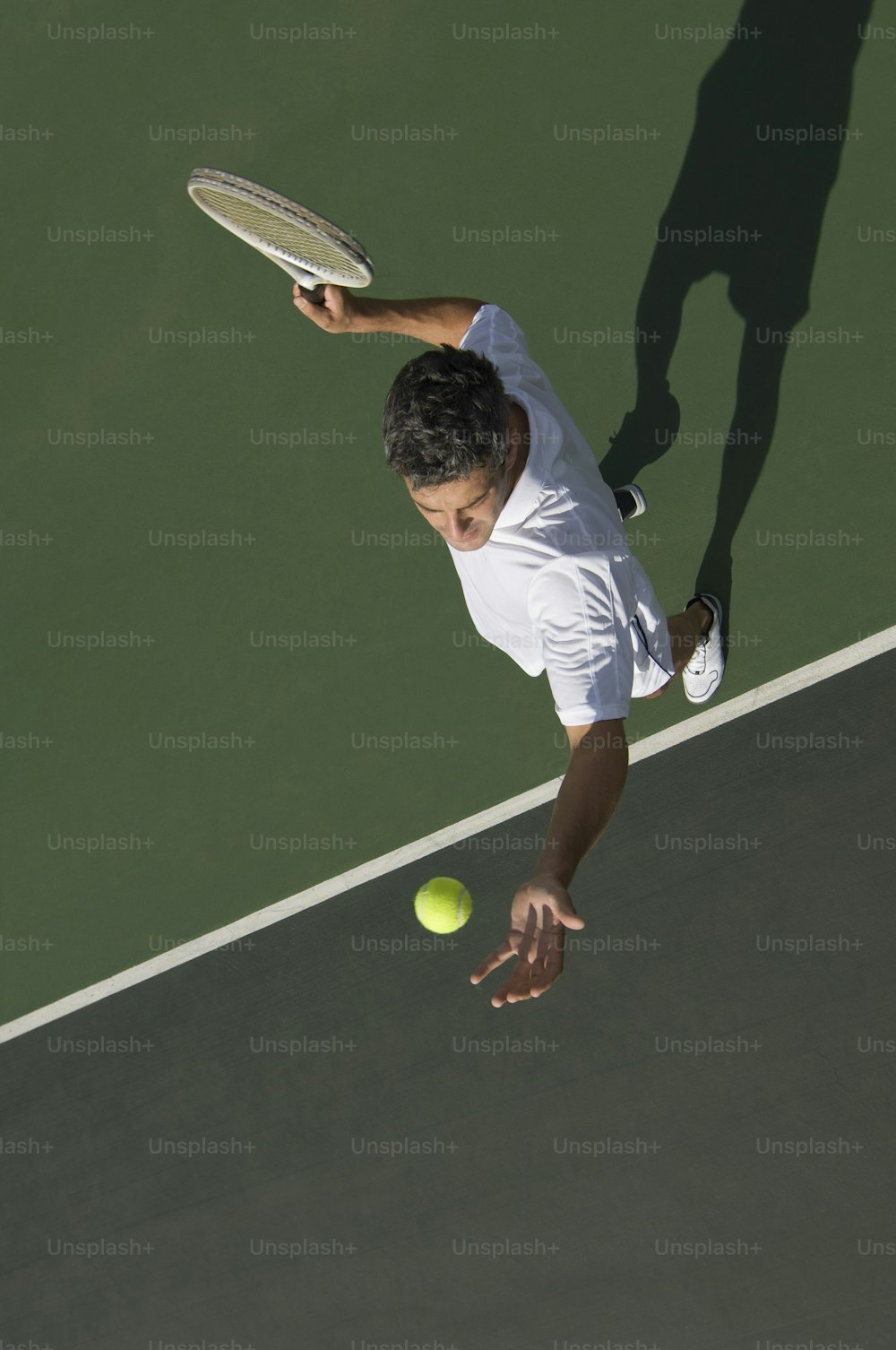 흰 셔츠와 반바지를 입은 남자가 테니스 게임을 하고 있다