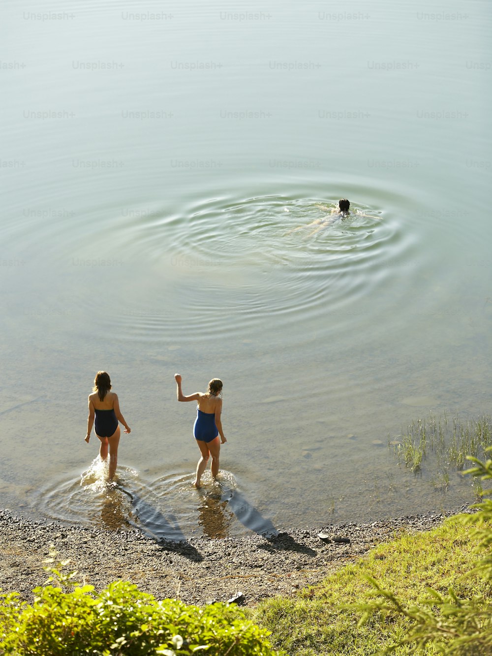 um casal de mulheres em pé em um corpo de água