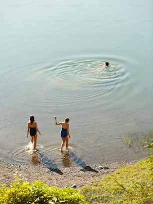 a couple of women standing in a body of water