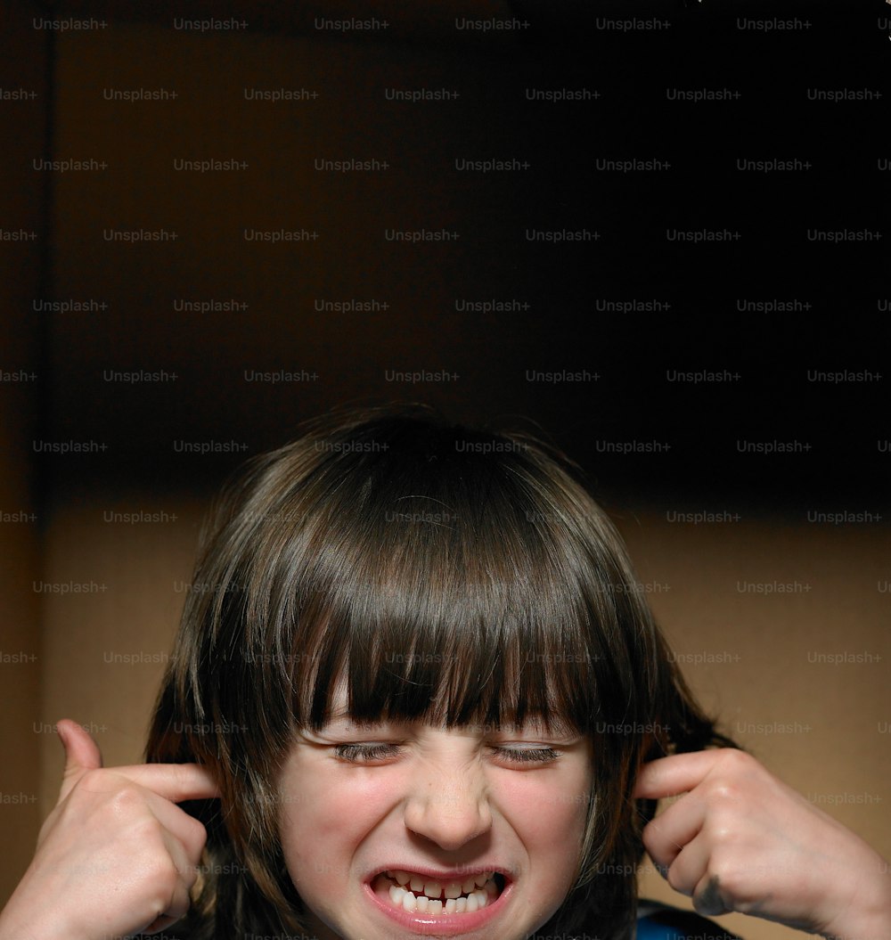 a young girl holding her hair in front of her face