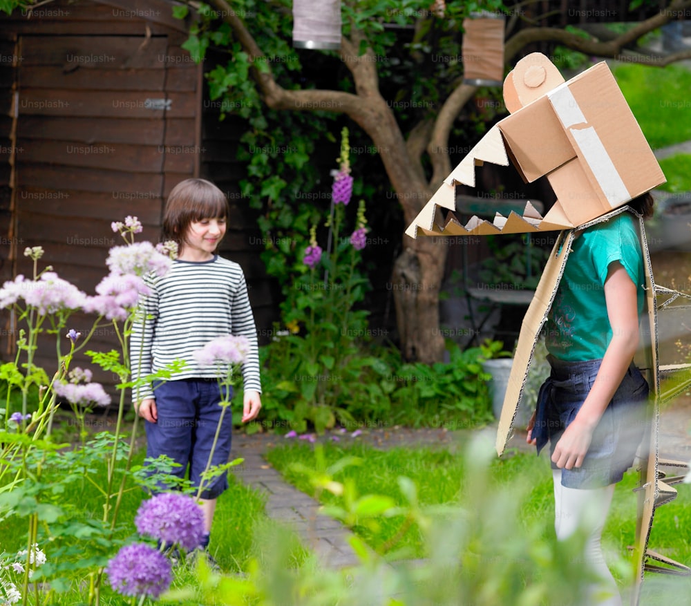 a boy and a girl standing in a garden