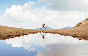 Hiker with backpack running on the mountain.