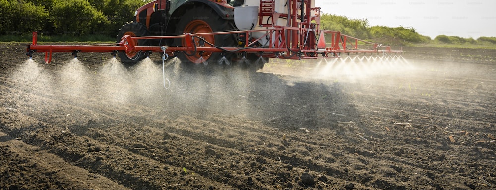 Tractor spraying pesticides on field  with sprayer