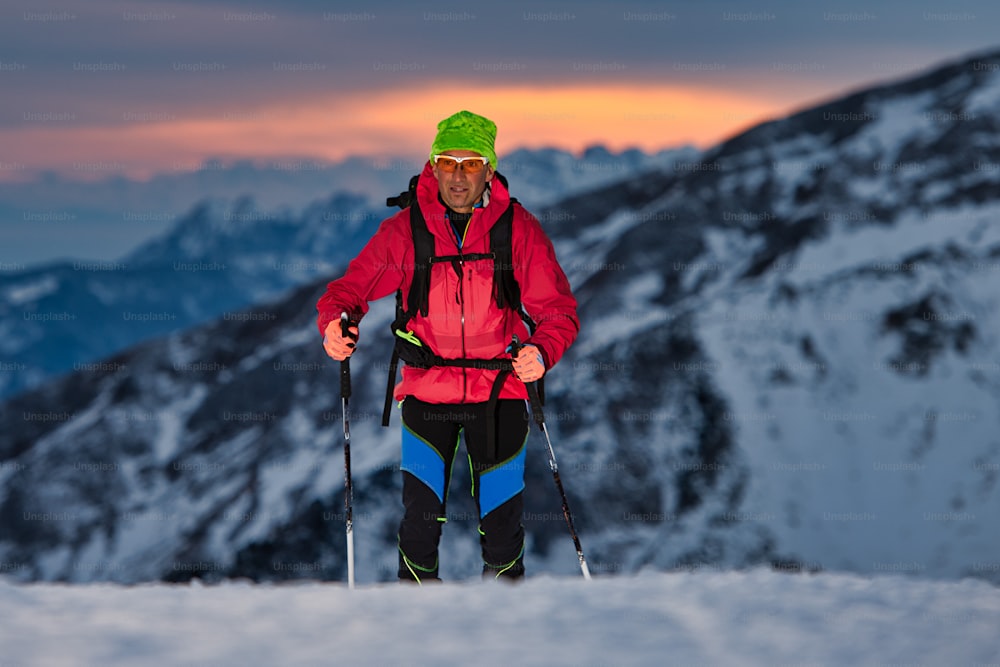 Bei Sonnenuntergang eine Skitour bergauf auf den Alpen