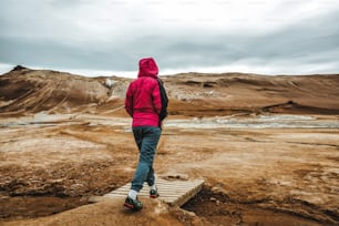 女性旅行者がアイスランドのフヴェリルを旅行します。クヴェリル(アイスランド語: Hverarond)は、マイヴァトンにある地熱地帯である。ヨーロッパのアイスランド北東部のクラフラにあるミーヴァトン湖の近くにある有名な目的地です。