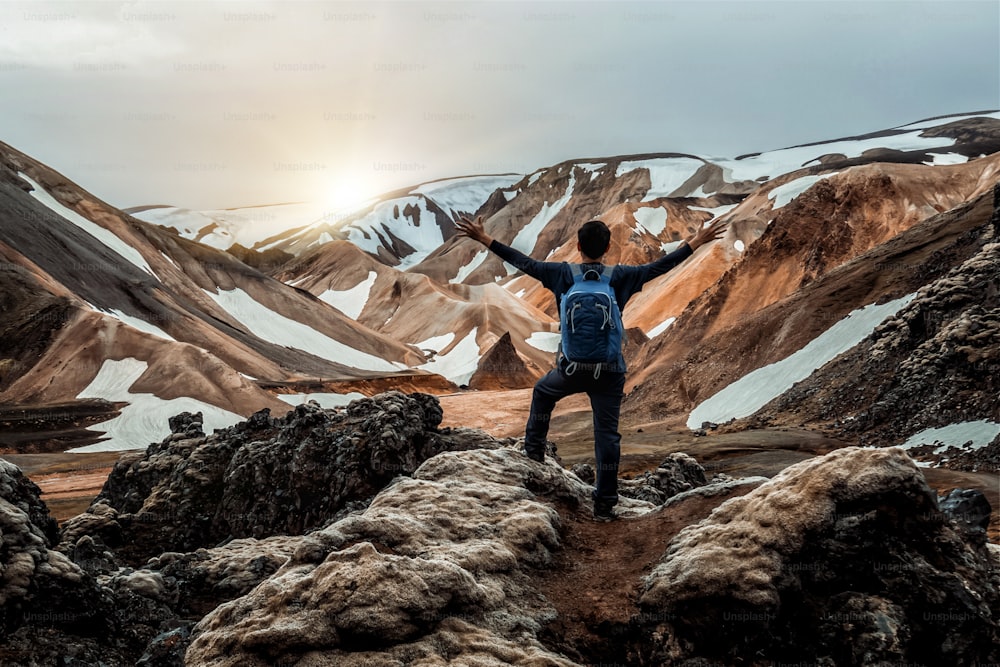 Escursionismo del viaggiatore a Landmannalaugar paesaggio naturale surreale nell'altopiano dell'Islanda, nordico, Europa. Bellissimo terreno di montagna innevato, colorato famoso per il trekking estivo, l'avventura e le passeggiate all'aria aperta.